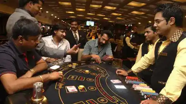 ผู้เล่นและดีลเลอร์รอบโต๊ะเกมไพ่ในคาสิโน ภาพปกคู่มือ Blackjack ออนไลน์